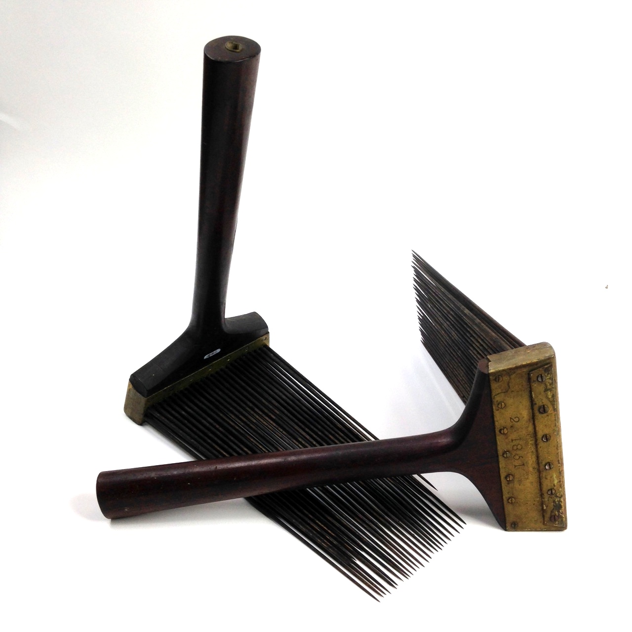 A pair of combs on a white surface.