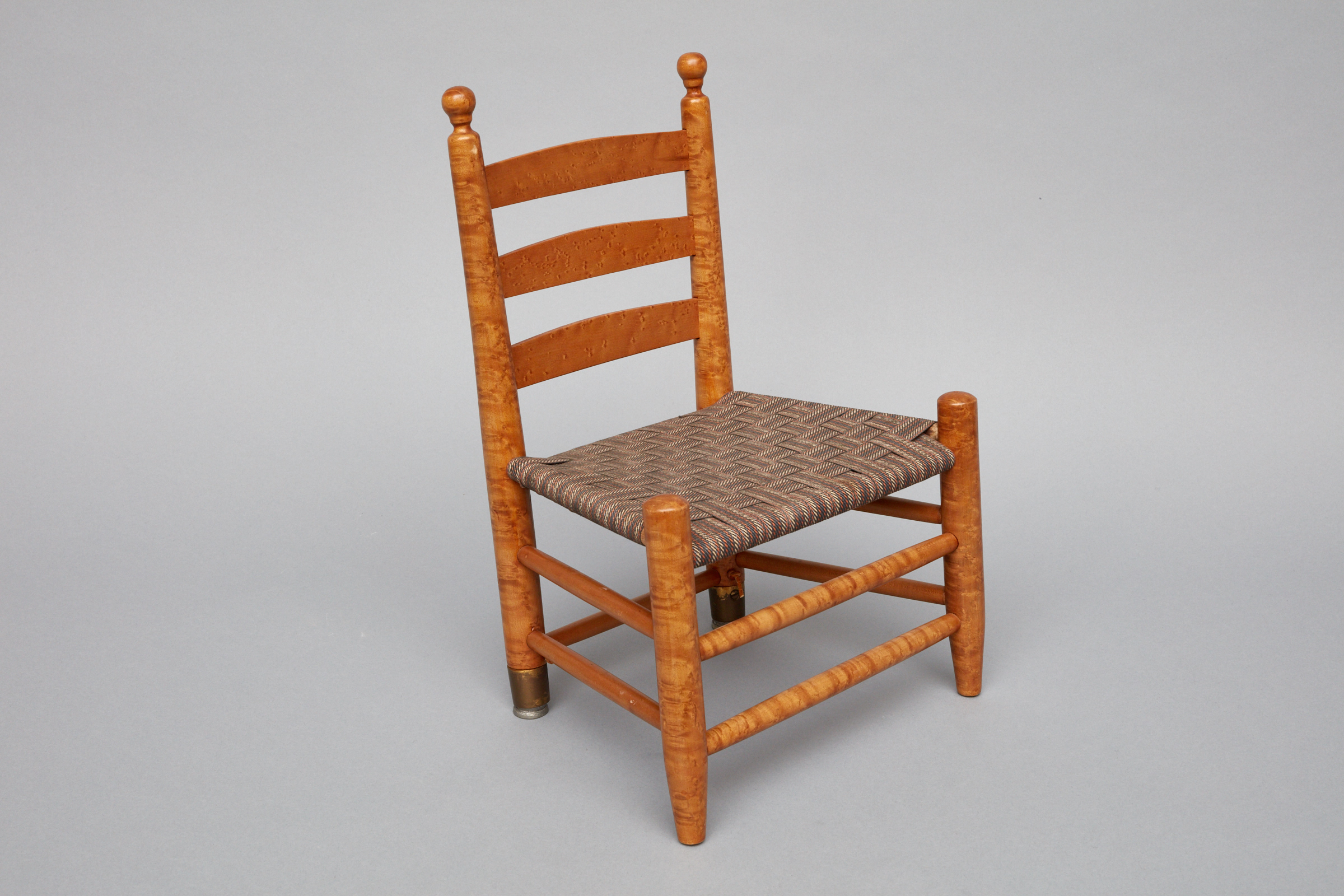 A small wooden chair with a wicker seat.