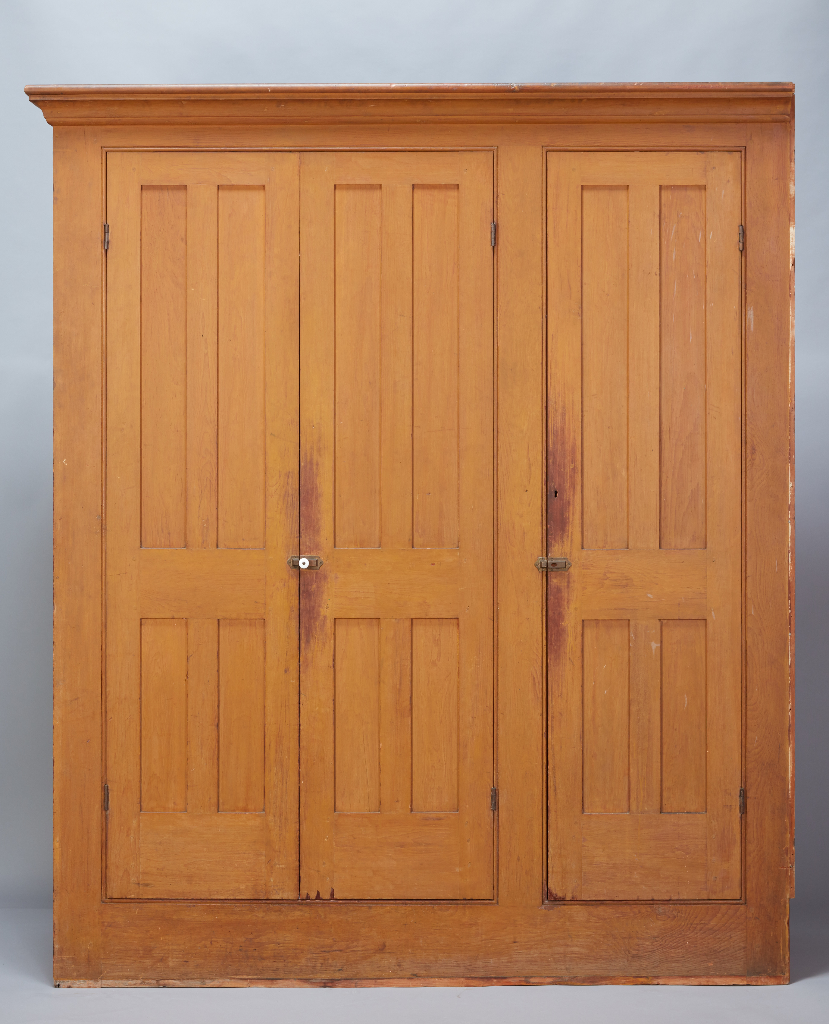 A pair of wooden armoires with doors.