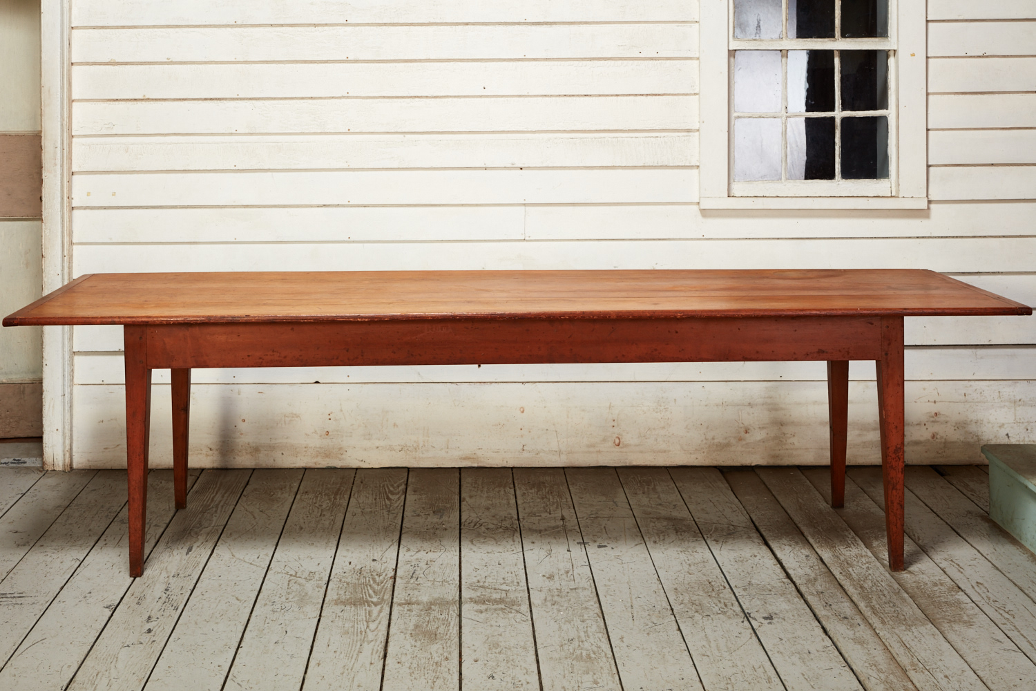 A wooden dining table in front of a house.