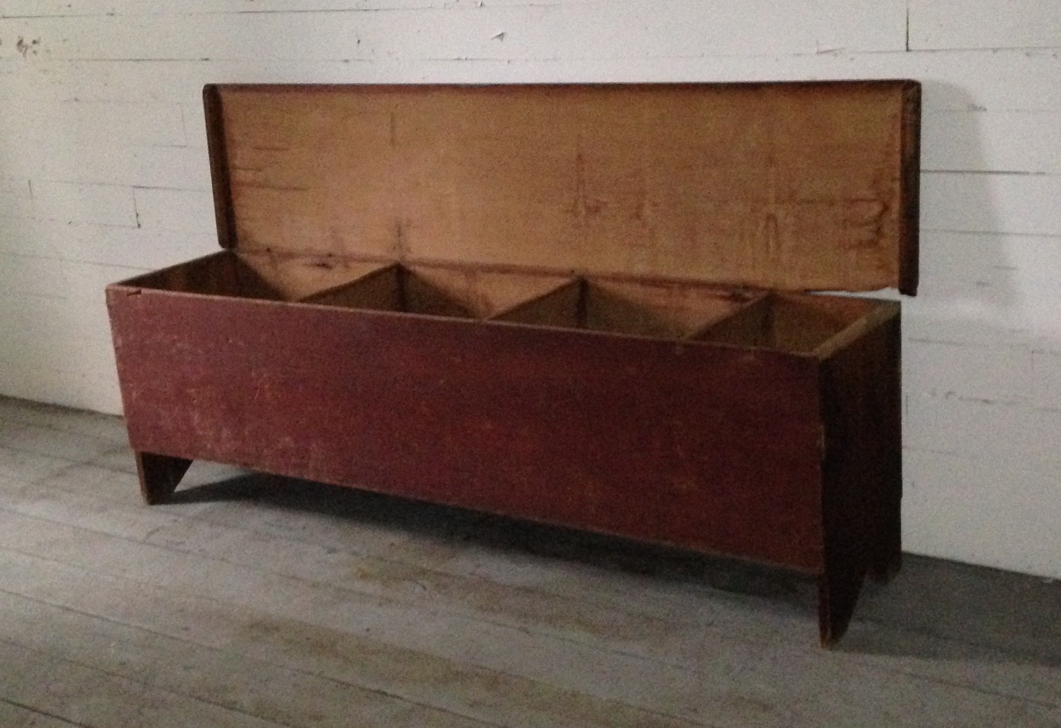 An old wooden storage bench with a lid on it.