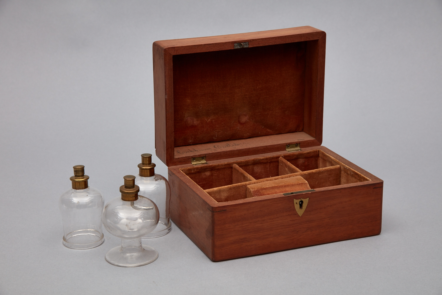 A wooden box with two glass bottles inside.