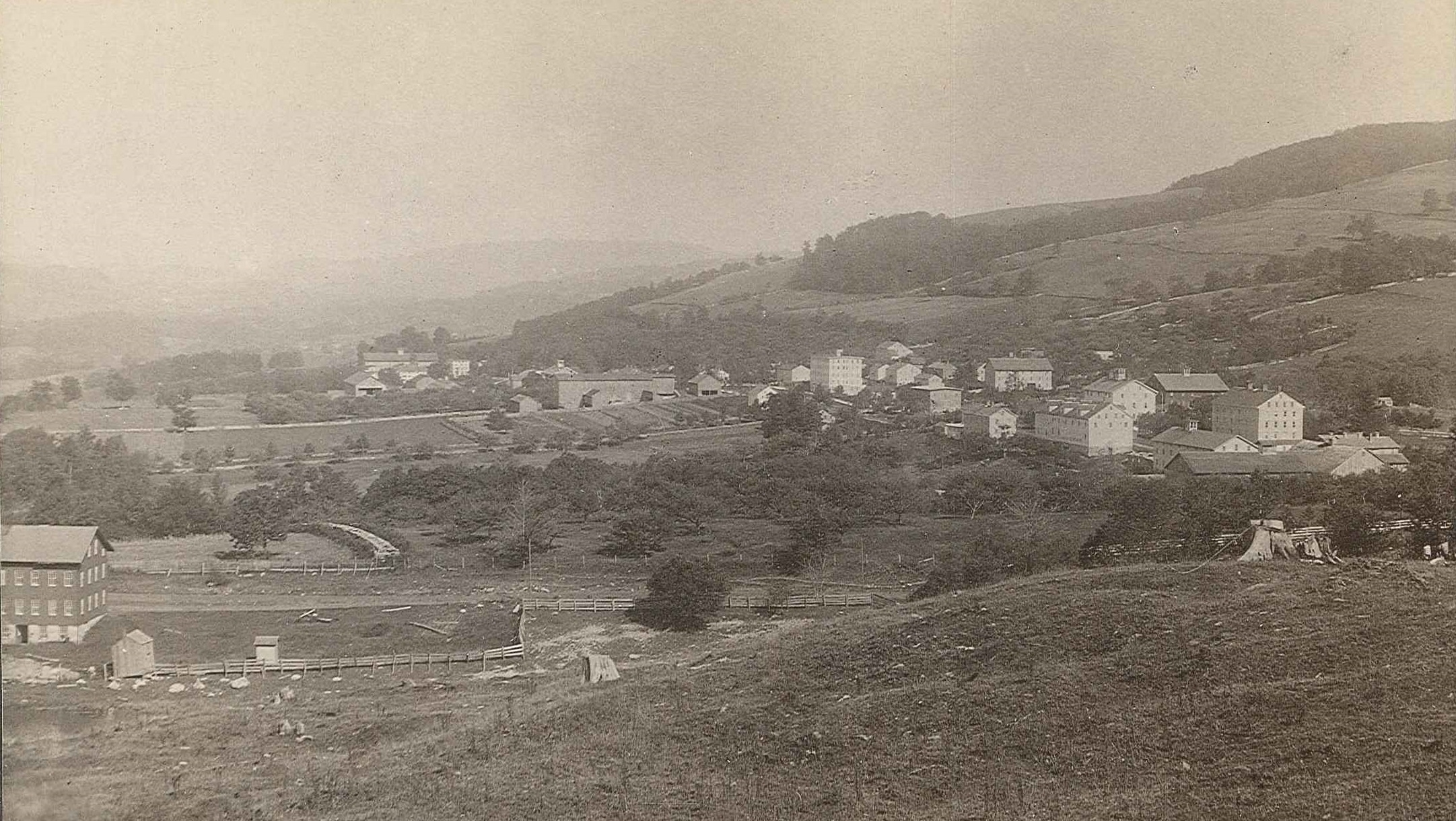 An old photo of a village on a hill.