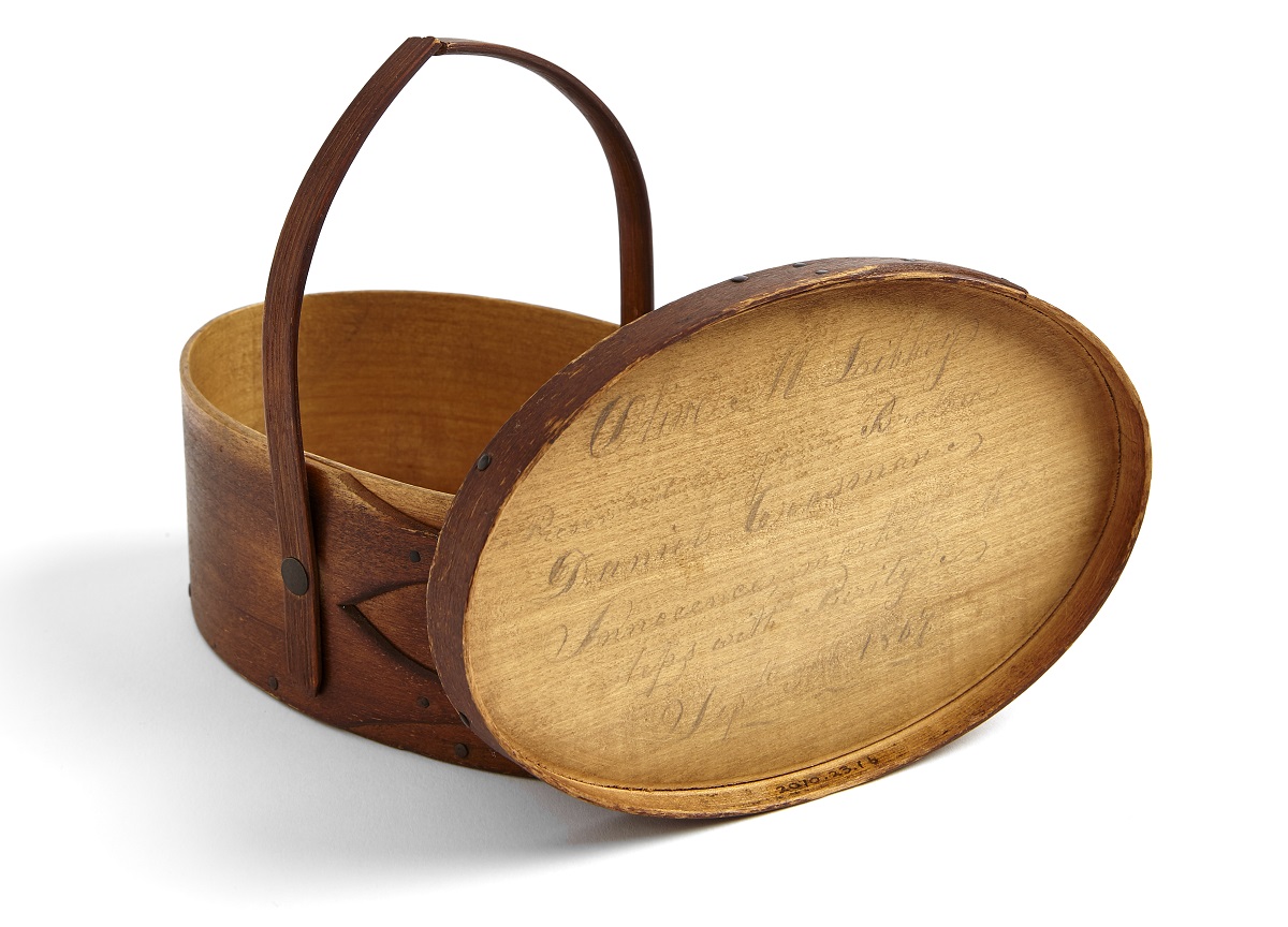 A wooden basket with writing on it.