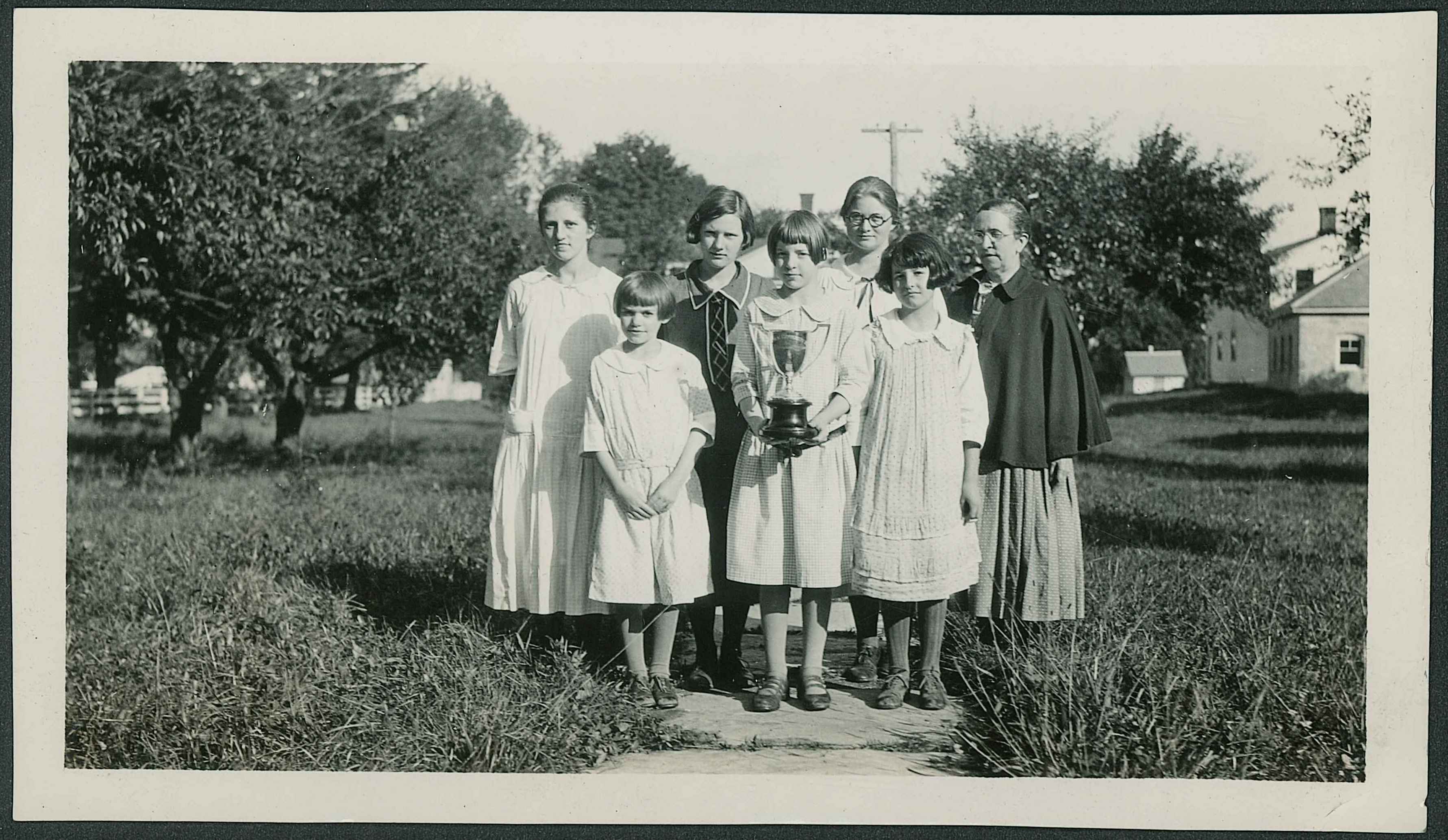 A black and white photo of a group of children posing for a picture.