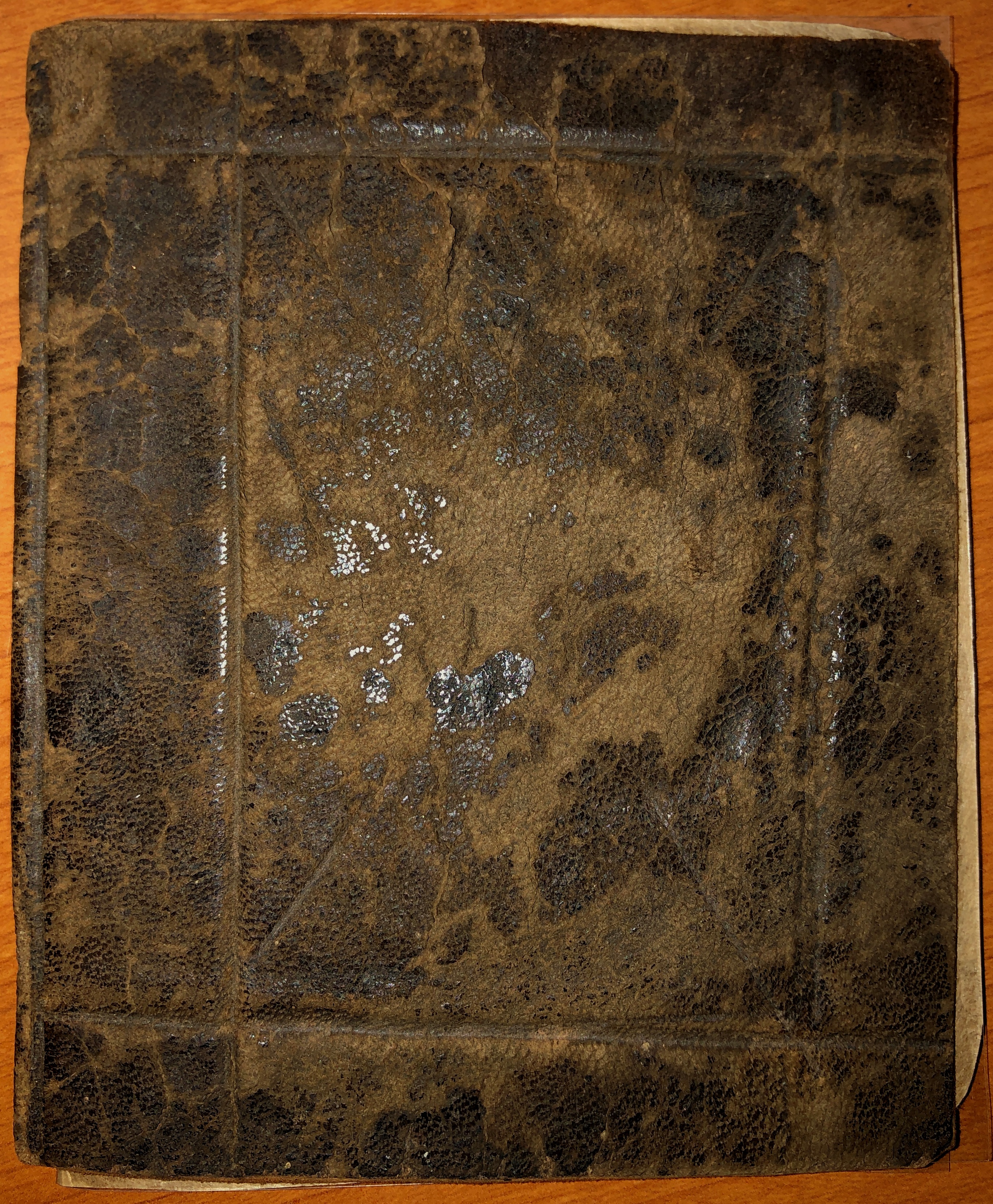 A brown leather book on a wooden table.