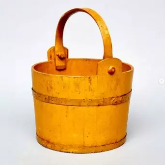 A yellow bucket with handles on a white background.