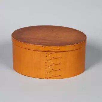 A round wooden box on a white background.